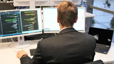 Solution Architect na frente de dois monitores