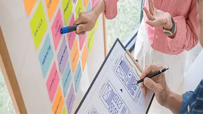 Pessoas apontando para o post it e escrevendo na prancheta